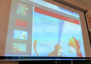 Na ekranie projektora przedstawiona jest treść bajki „Czerwony Kapturek – Misja Czarny Smog”.